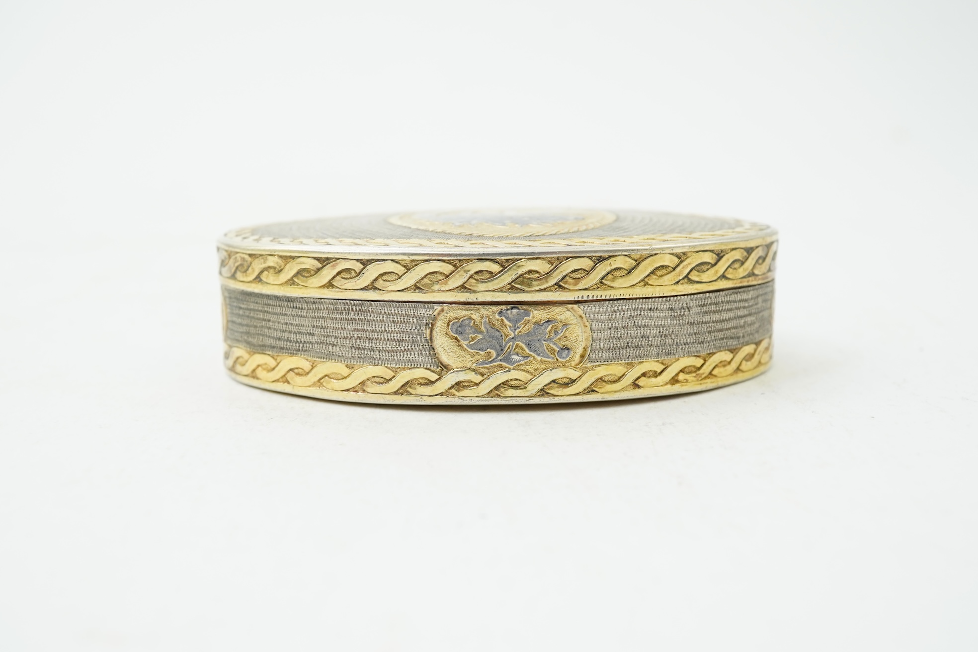 A 19th century Swiss? parcel gilt white metal oval snuff box with hinged cover